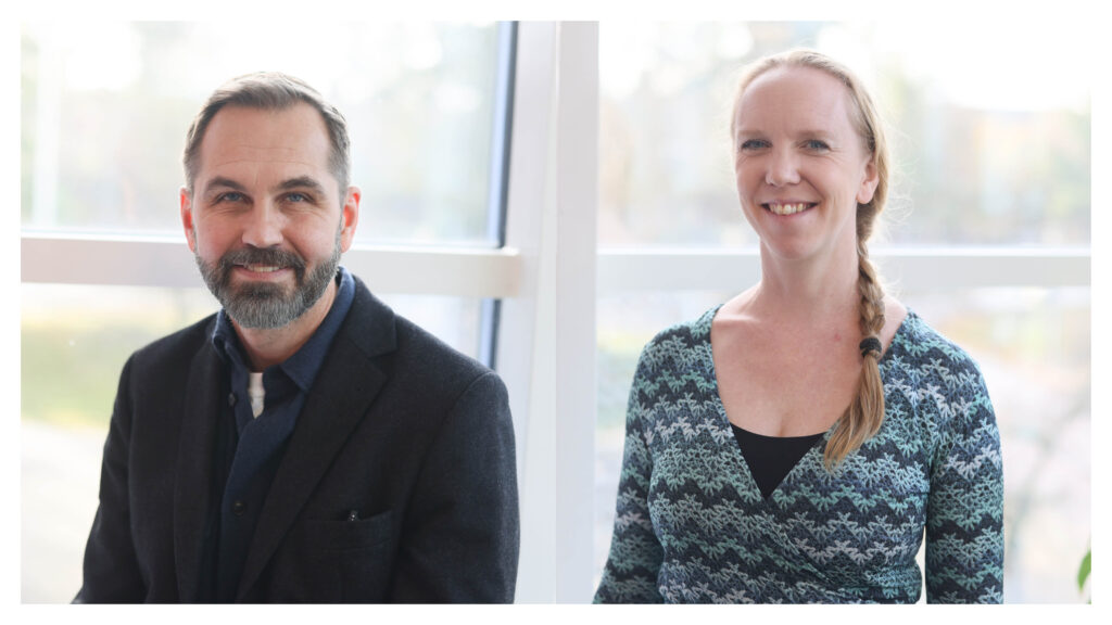 En man med skägg i mörk kavaj och en kvinna med lång fläta i mönstrad topp, båda leende och sittande inomhus framför stora fönster med mjukt dagsljus.